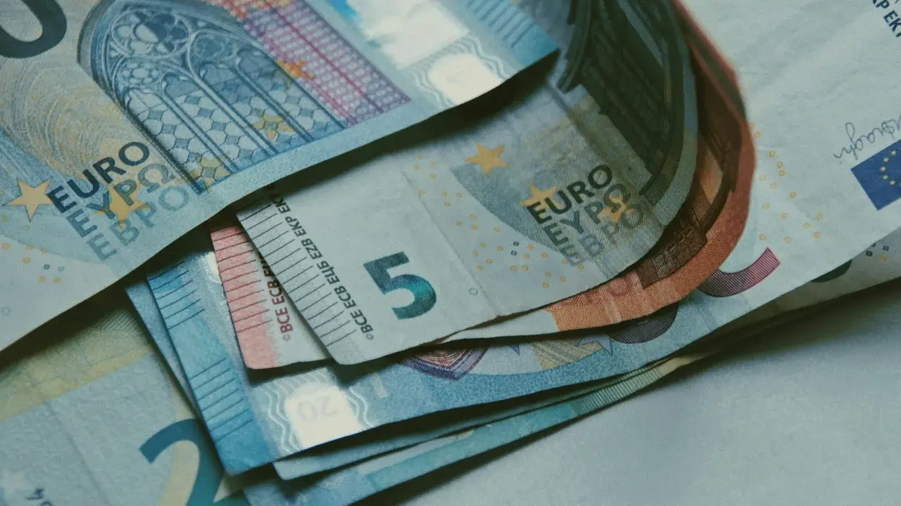 Billetes de euros apilados, incluyendo un billete de 5 euros, que podrían ser parte de la base reguladora para la jubilación.