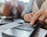 Un hombre mayor calcula con una calculadora, ayudando a alguien a saber mi base reguladora.