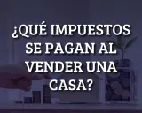 ¿Qué impuestos se pagan al vender una casa? Mano colocando monedas en una alcancía con una planta, junto a una casa de juguete y pilas de monedas.