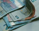 Billetes de euros apilados, incluyendo un billete de 5 euros, que podrían ser parte de la base reguladora para la jubilación.