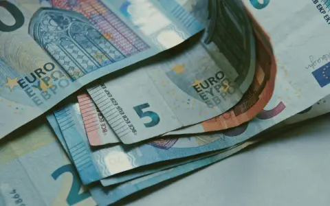 Billetes de euros apilados, incluyendo un billete de 5 euros, que podrían ser parte de la base reguladora para la jubilación.
