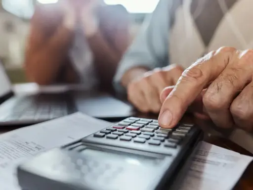 Un hombre mayor calcula con una calculadora, ayudando a alguien a saber mi base reguladora.