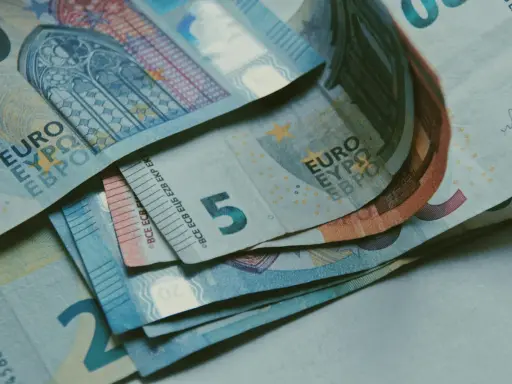 Billetes de euros apilados, incluyendo un billete de 5 euros, que podrían ser parte de la base reguladora para la jubilación.