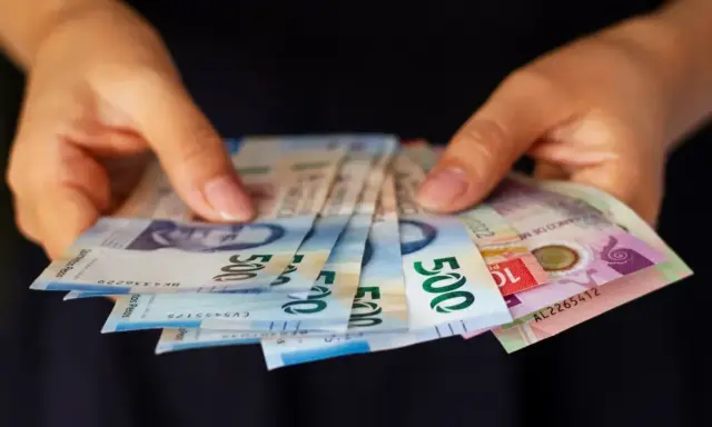 Manos sostienen billetes de 500 pesos, una forma de sacar dinero sin tarjeta.