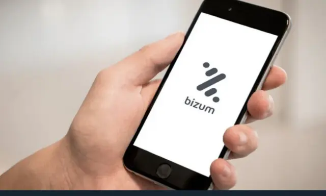 Mano sujetando un smartphone con la app Bizum abierta. Aprende como devolver un bizum fácilmente.