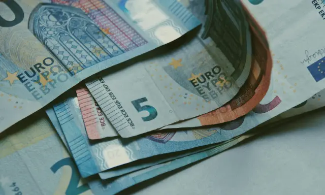Billetes de euros apilados, incluyendo un billete de 5 euros, que podrían ser parte de la base reguladora para la jubilación.