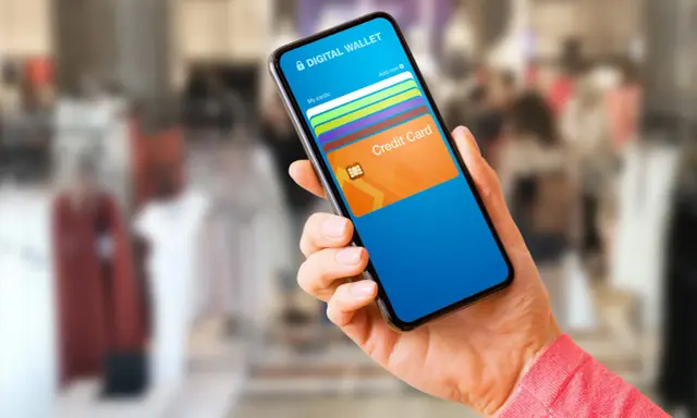 Mano sostiene un teléfono con una aplicación de wallet digital que muestra tarjetas de crédito.